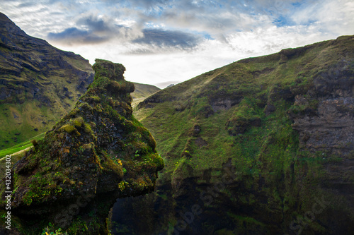 A rock formation which looks like a troll's head overlooks Skogafoss, a waterfall in Southern Iceland, near the town of Hvolsvollur.