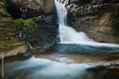 A tourist poses near a waterfall in Pico Bonito National Park, Honduras. photo