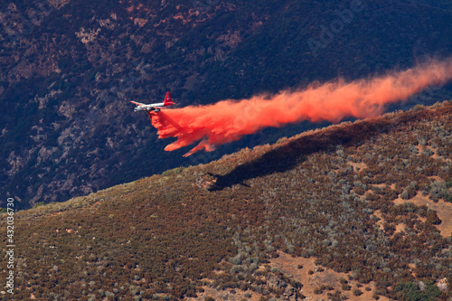 Fixed-wing aircraft dropping retardant along ridge in advance of approaching Rim Fire, Sierra Nevada, California