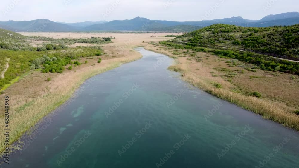 Aerial drone view of lake surrounded by reeds. Beautiful landscape. Colorful swampy marsh in spring. Hutovo blato, nature reserve and bird reserve located in Bosnia and Herzegovina. Aerial drone view of lake surrounded by reeds. Beautiful landscape. Colorful swampy marsh in spring. Hutovo blato, nature reserve and bird reserve located in Bosnia and Herzegovina.