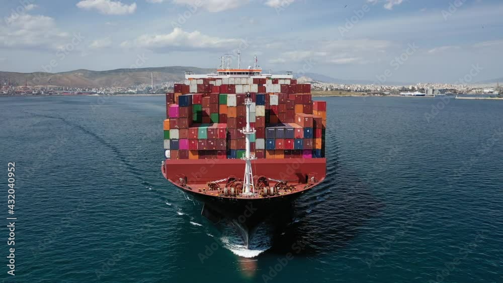 Aerial drone video of huge container carrier tanker ship front bow cruising deep blue open ocean sea