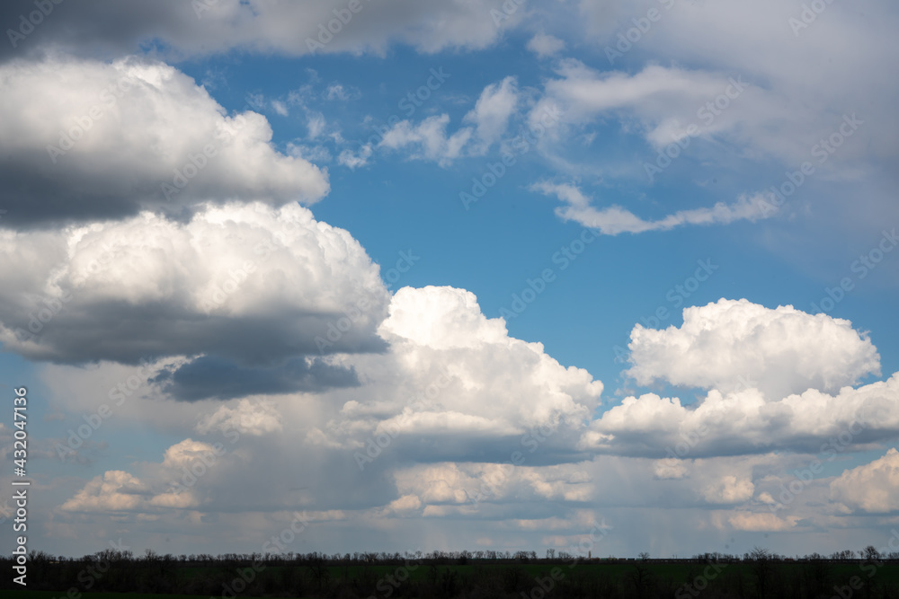Bright large clouds and blue sky. Thin horizon line. Bright large clouds and blue sky. Thin horizon line.