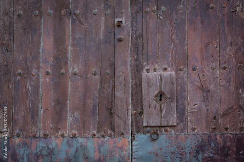 antique brown wooden door with an handle and a lock
