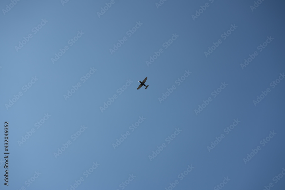Small black plane on a background of blue sky. Small black plane on a background of blue sky.