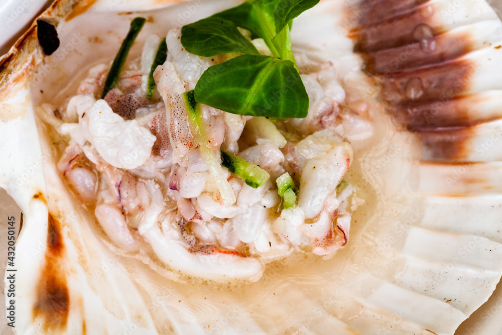 Ceviche. Finely chopped raw squid marinated in lemon juice served in seashell.