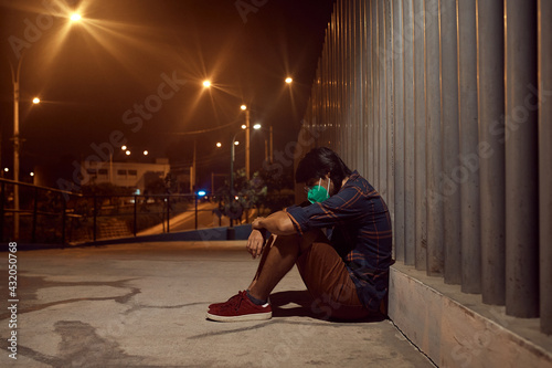 Foto Hombre triste sentado en el suelo afuera de un hospital