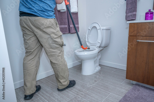Man using an auger on a toilet