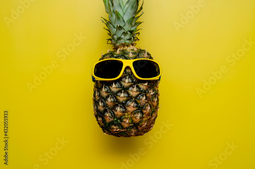 Pineapple in the sunglasses on a yellow background