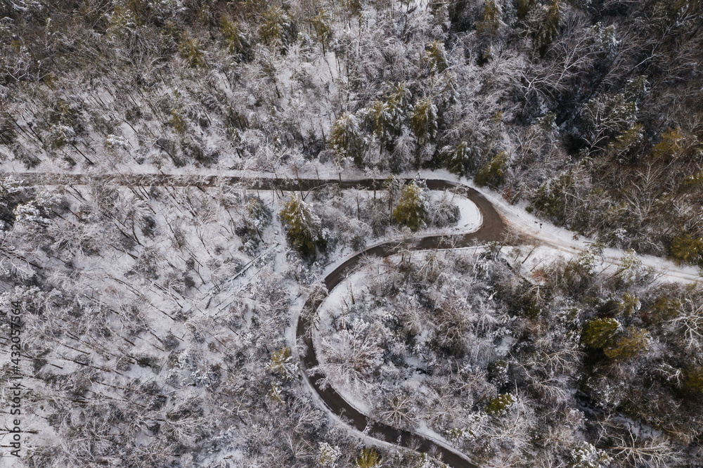 Aerial of Snow Covered Pine Ridge & Winding Road - Red River Gorge Geological Area - Appalachian Mountains of Eastern Kentucky