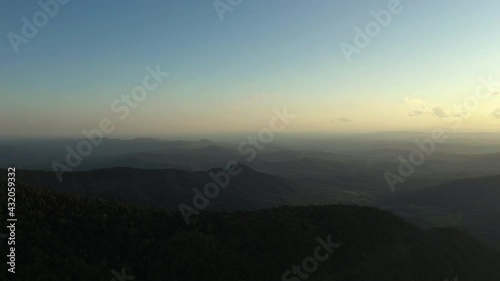 Aerial shot of mountain landscape with clear blue sky at Border Ranges National Park, New South Wales in Australia. Panning drone shot and big mountains can be seen in the background. photo