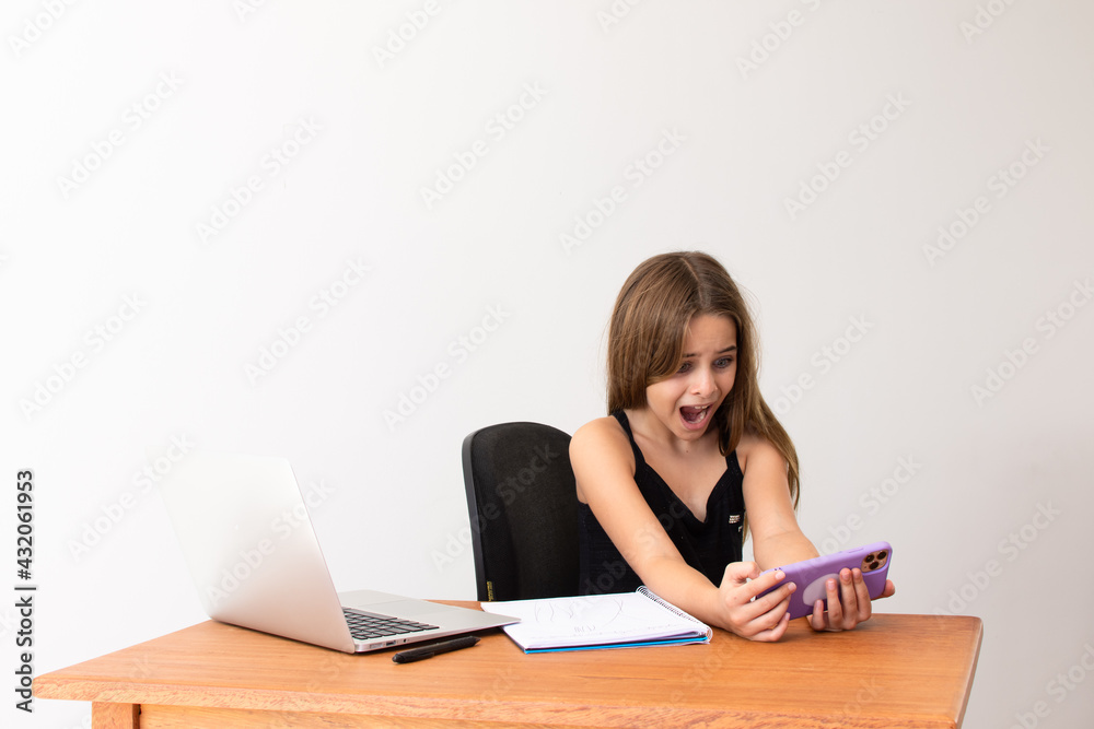 Criança estudando virtualmente com celular e computador Criança estudando virtualmente com celular e computador