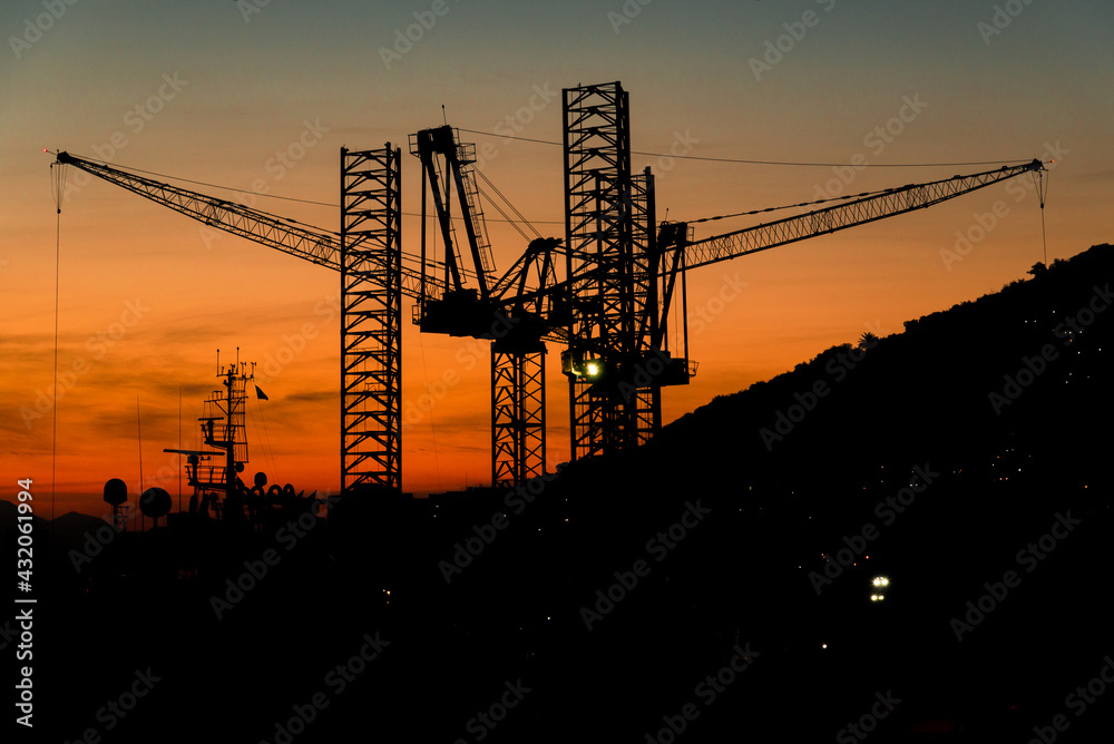 Silhouette of Industrial Cranes of Sunset