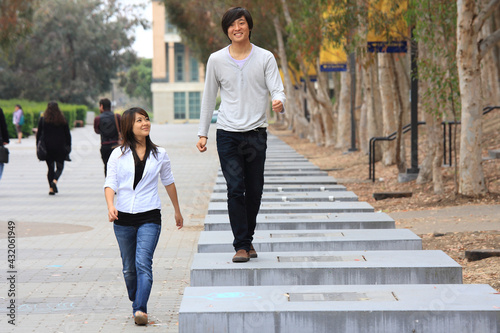 Japanese male and female students walking side by side  © funbox