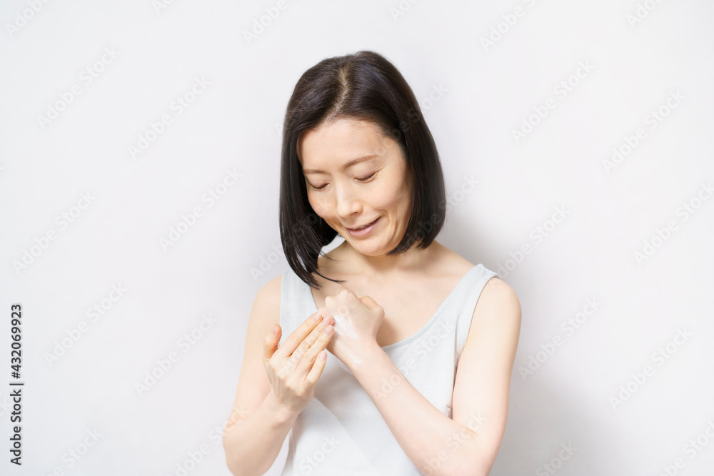 手の甲にクリームを塗る女性 手の甲にクリームを塗る女性
