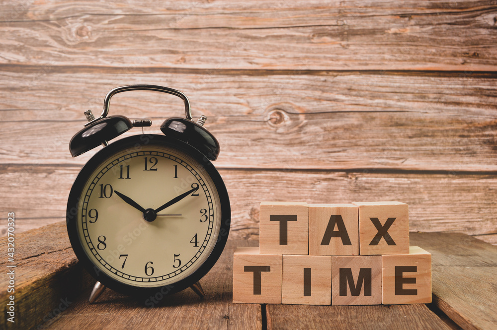 Alarm clock and wooden cubes with word TAX TIME Alarm clock and wooden cubes with word TAX TIME