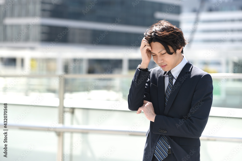 悩むビジネスマンの男性 悩むビジネスマンの男性
