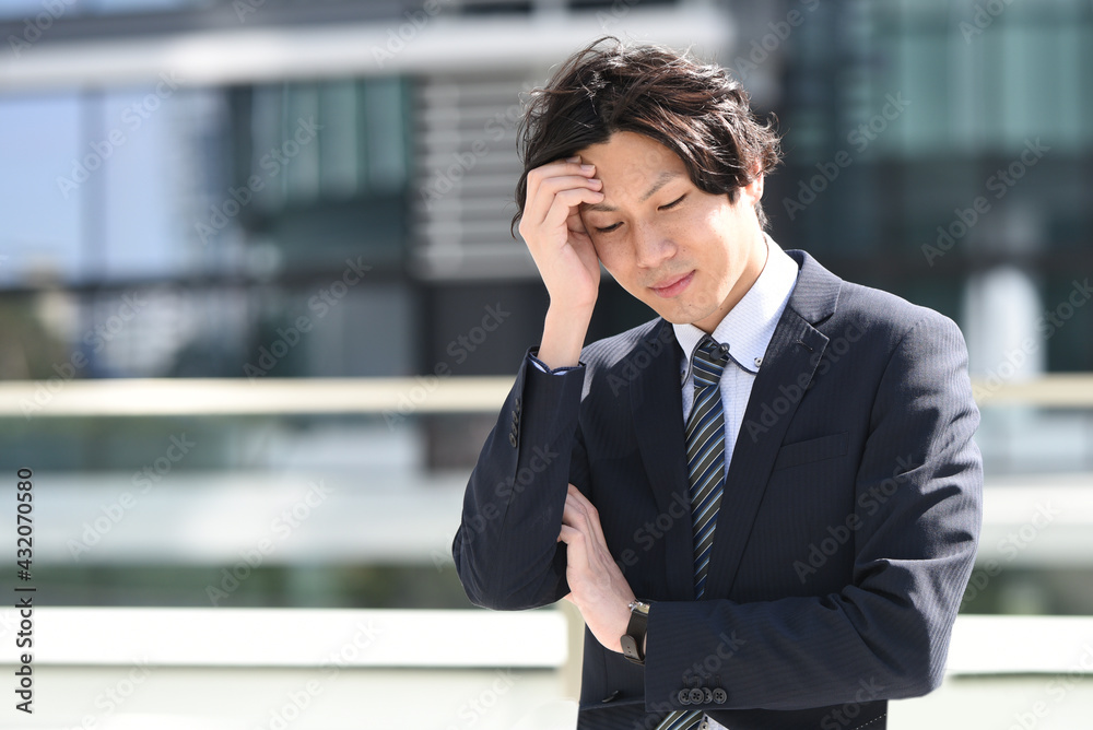 悩むビジネスマンの男性 悩むビジネスマンの男性