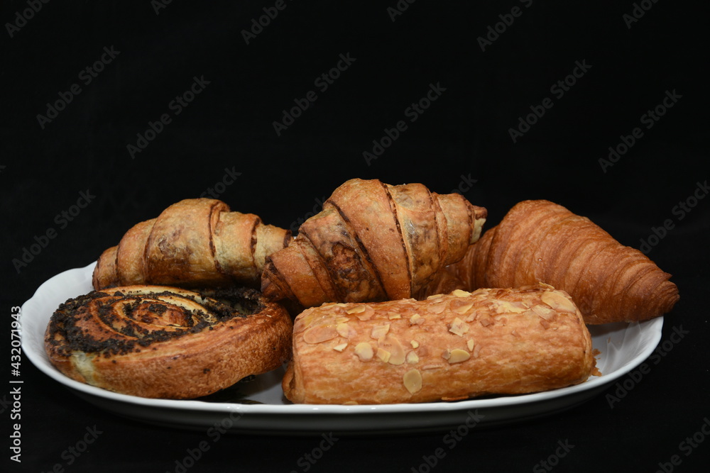 plate with croissants and strudel with almonds
