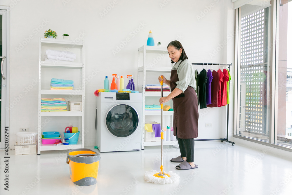 Senior asian woman mopping the floor at home. Senior asian woman mopping the floor at home.