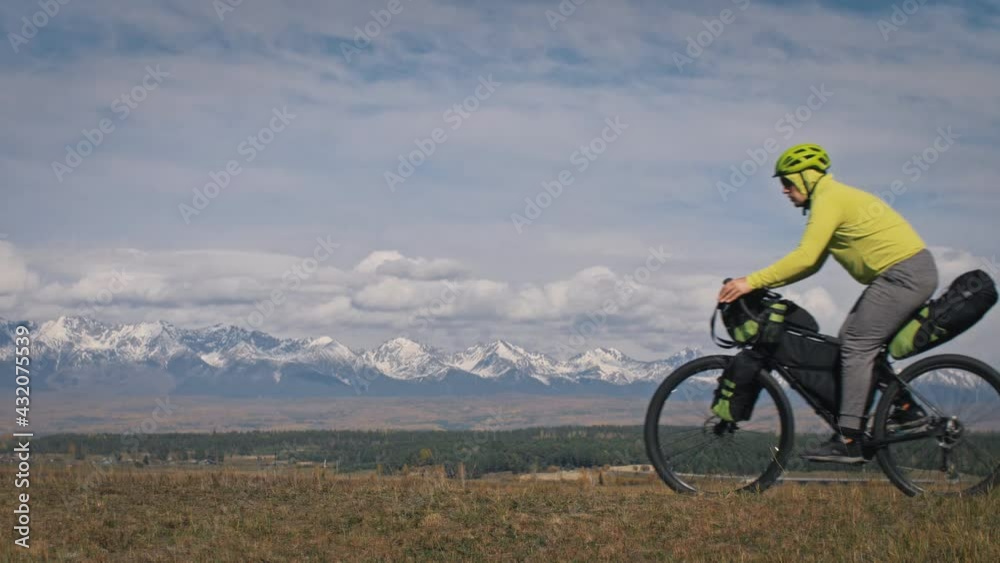 The man travel on mixed terrain cycle touring with bikepacking. The traveler journey with bicycle bags. Sport tourism bikepacking. The man travel on mixed terrain cycle touring with bikepacking. The traveler journey with bicycle bags. Sport tourism bikepacking.