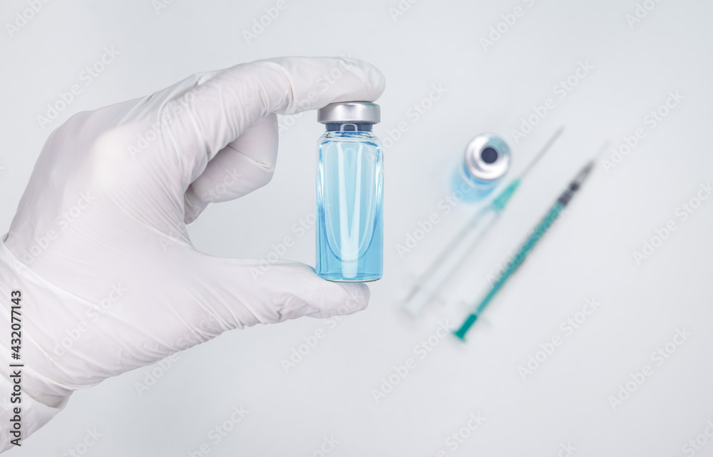 Coronavirus vaccination and immunization concept. A syringe is injected into a vial. Plastic medical syringe and vial vaccine. Monochromatic image of glass vials and a syringe. Fight pandemic. Coronavirus vaccination and immunization concept. A syringe is injected into a vial. Plastic medical syringe and vial vaccine. Monochromatic image of glass vials and a syringe. Fight pandemic.
