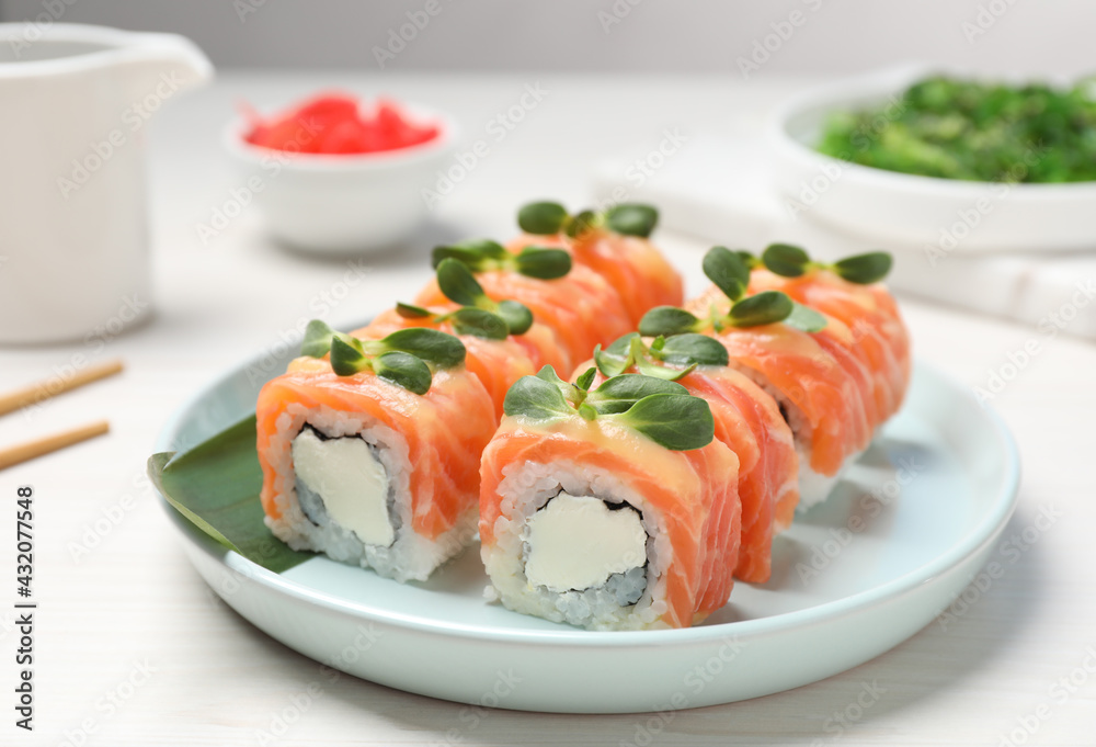 Tasty sushi rolls with salmon served on white table Tasty sushi rolls with salmon served on white table