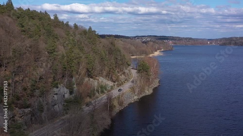 Car driving beside a lake in Sweden, outside Gothenburg, Sweden. Filmed by 4k Drone, Dji mavic photo