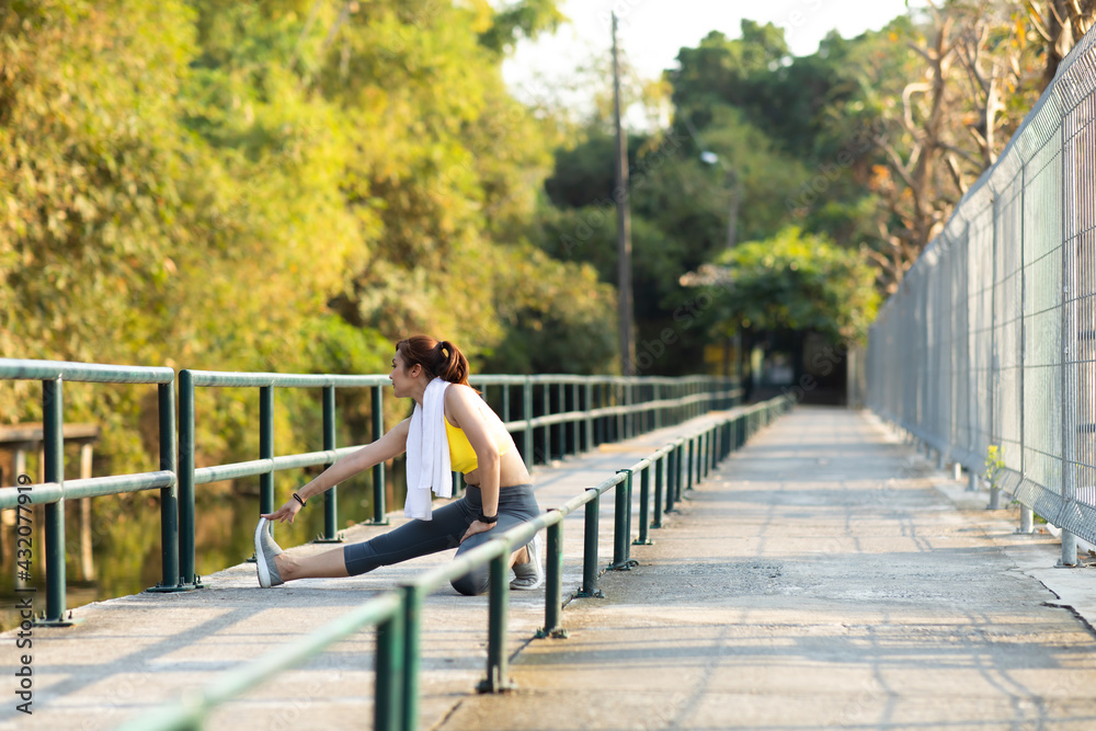 Portrait of beautiful healthy young woman warming up and exercising outdoors in the park. stretching arms and legs Portrait of beautiful healthy young woman warming up and exercising outdoors in the park. stretching arms and legs