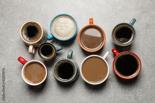 Cups of fresh aromatic coffee on light grey table, flat lay