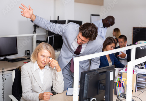 Foto Male angry boss blaming adult female office worker in office