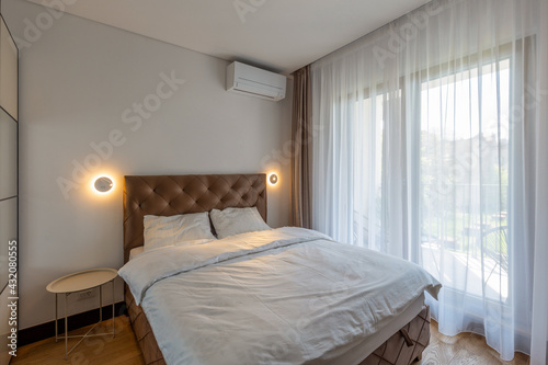 Bedroom interior with large windows and curtains