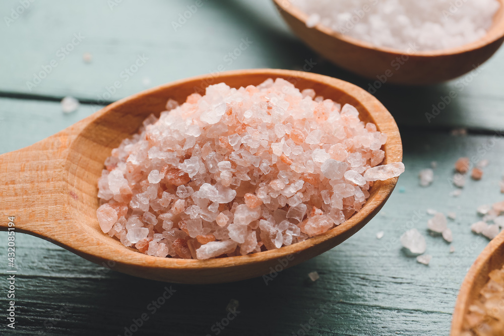 Spoon with salt on color wooden background Spoon with salt on color wooden background