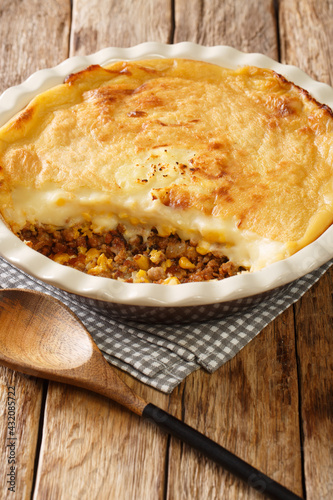 Pate chinois is a French Canadian dish similar to the English shepherd's pie it is a traditional recipe in both Quebec cuisine closeup in the baking dish on the table. Vertical