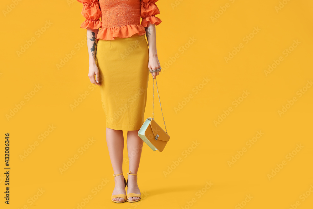 Stylish young woman with bag on yellow background Stylish young woman with bag on yellow background