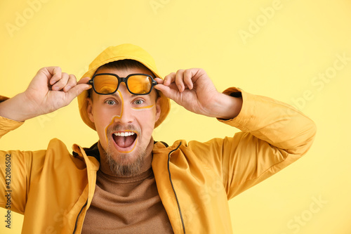 Excited young man on yellow...