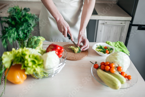 male hands chopping salad and onion, cooking healthy food in the kitchen.