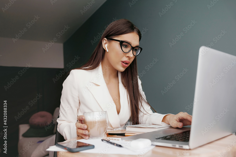 Businesswoman working on laptop computer sitting at home managing her business via home office during Coronavirus or Covid-19 quarantine Businesswoman working on laptop computer sitting at home managing her business via home office during Coronavirus or Covid-19 quarantine