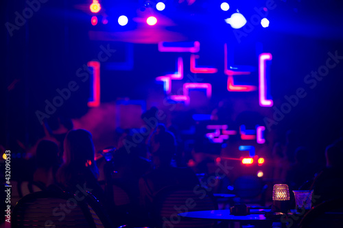 Scene with Neon lights . Group of happy womans at concert in night club. Nigh life concept .