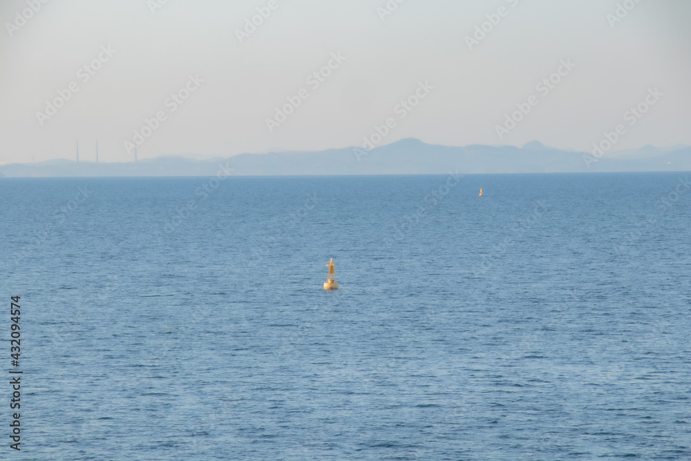 青い海と遠くに見える島、黄色い浮