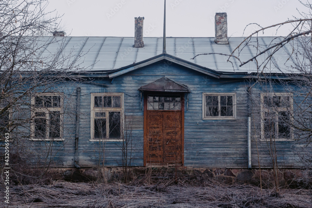 An old blue building with brown massive doors and old frames. An old blue building with brown massive doors and old frames.