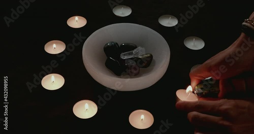 Lighting candles for a candle magick crystal cleansing ritual photo