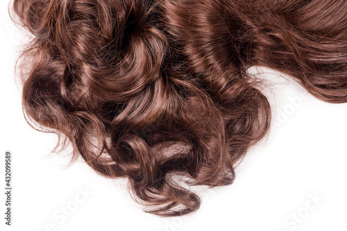 Brown hair texture. Wavy long curly light brown hair close up isolated on white. Hair extensions, materials and cosmetics, hair care, wig. Hairstyle, haircut or dying in salon