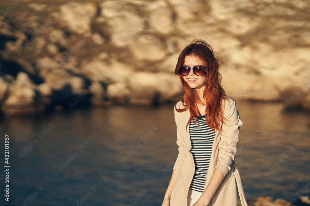 woman travels in the mountains adventure tourism model near the river in summer glasses woman travels in the mountains adventure tourism model near the river in summer glasses