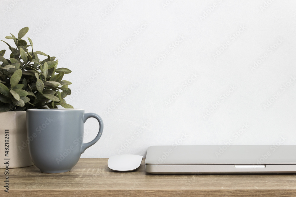 Grey coffee cup, computer, mouse mock up on table over the white wall. Grey coffee cup, computer, mouse mock up on table over the white wall.