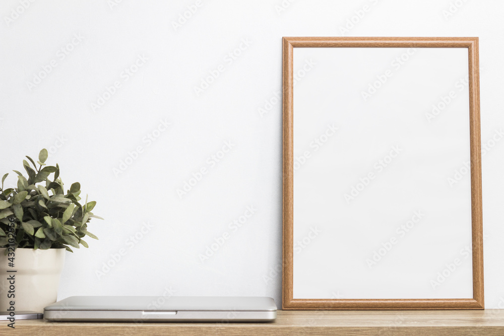 Computer, plant and photo frame on table. Computer, plant and photo frame on table.