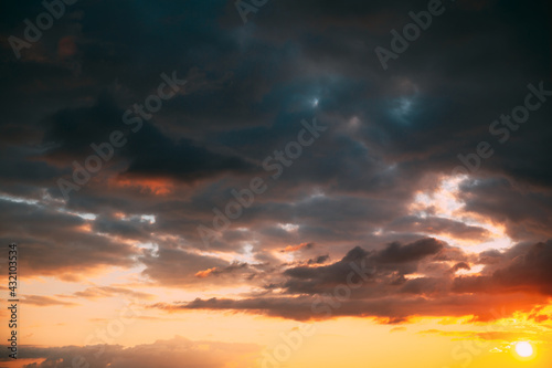 Sunset Cloudy Sky With Fluffy Clouds. Sunset Sky Natural Background. Sunrays, sunray, ray, Dramatic Sky. Sunset In Yellow, Orange, Pink Colors © Grigory Bruev