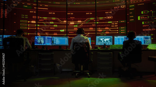 Professional IT Technical Support Specialists and Software Programmer Working on Computers in Monitoring Control Room with Digital Screens with Server Data, Blockchain Network and Surveillance Maps. 