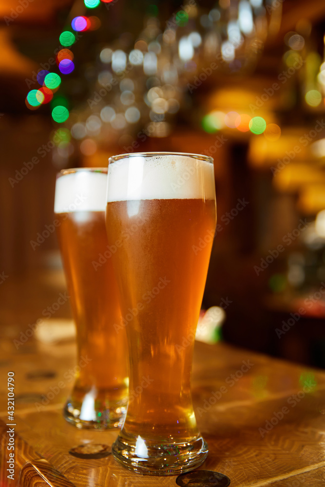 Two glasses of fresh foamy beer on the bar counter Two glasses of fresh foamy beer on the bar counter