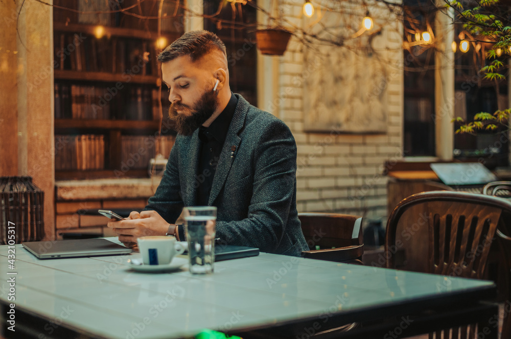 Young attractive businessman using a smartphone in a cafe