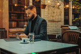 Young attractive businessman using a smartphone in a cafe